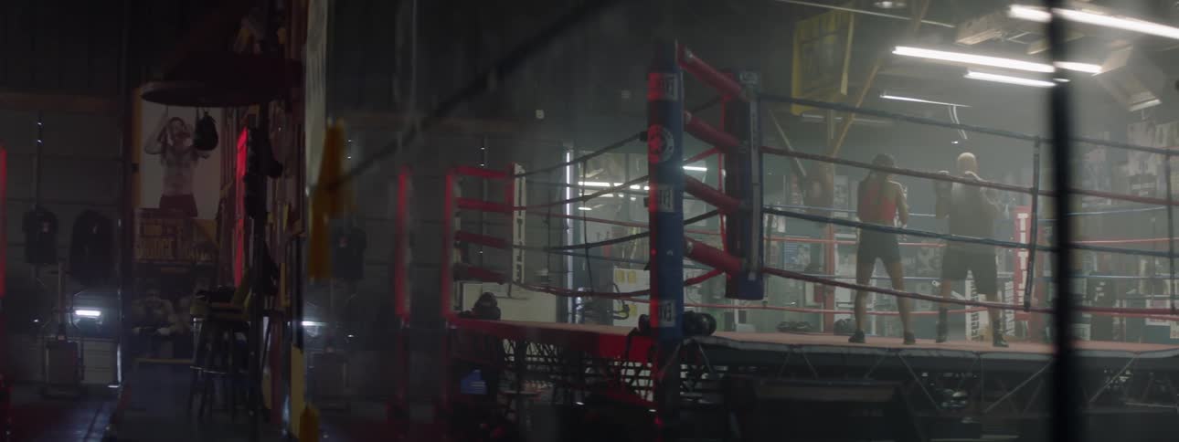 A boxer trains with a coach in a boxing ring