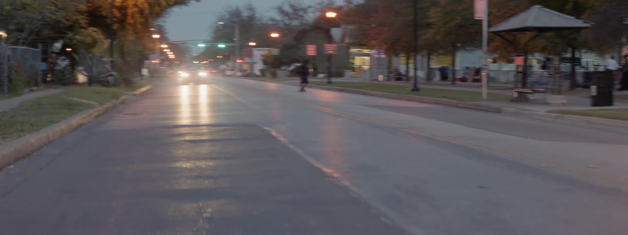 A man walks across a road in front of an oncoming car