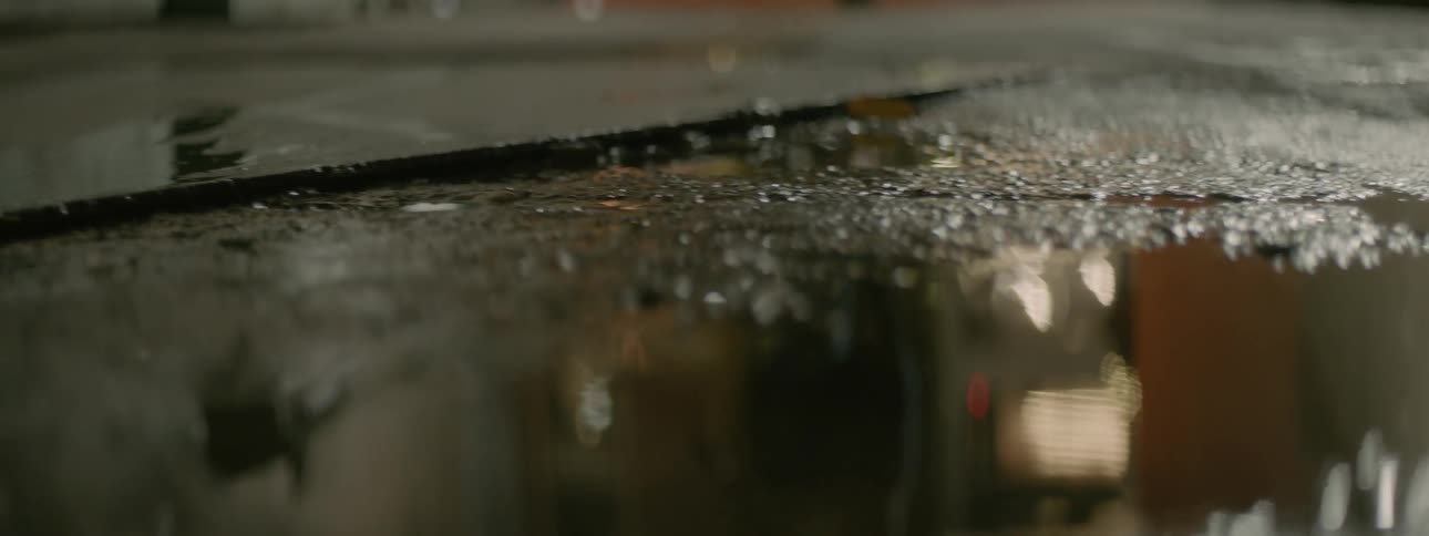 A jogger is passing by a puddle in the street