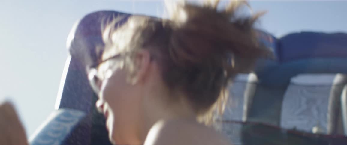 Woman bouncing playfully with a child outdoors on a clear day