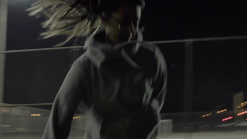 A woman practices soccer dribbles