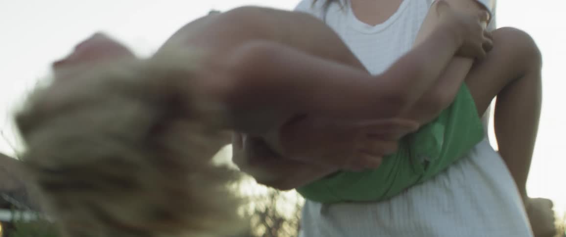 A woman holds and swings a young child