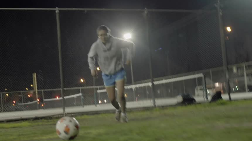 A woman kicks a soccer ball