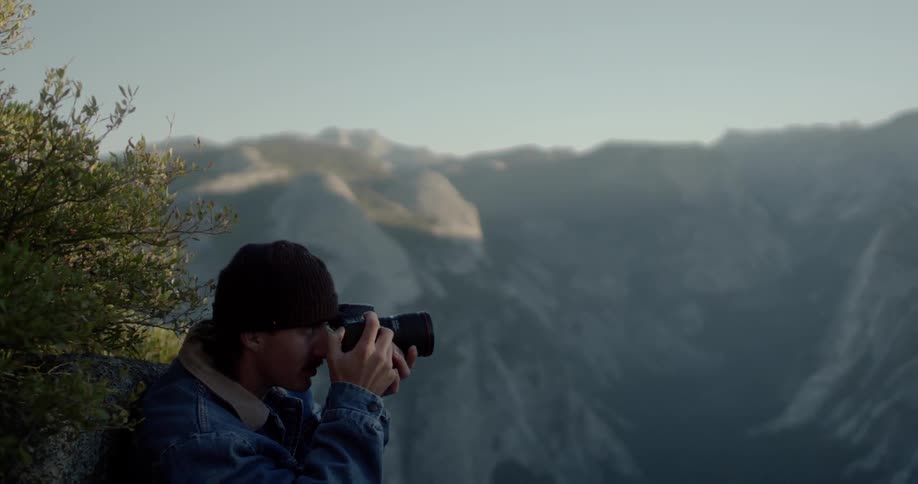 Man takes pictures of mountains on a sunny day