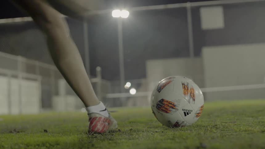A woman kicks a soccer ball