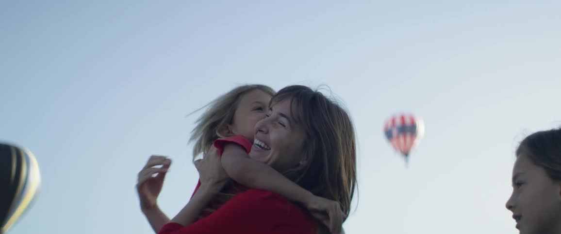 A woman lifts up a young boy and hugs him