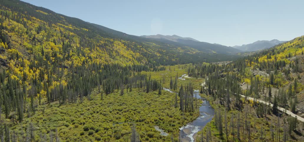Trees and shrubs cover the valley between mountains