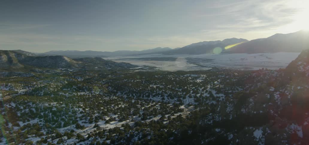 Sunlight is shining on a snow-covered valley in winter