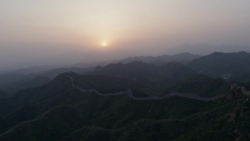 The sun shines above the tall mountains