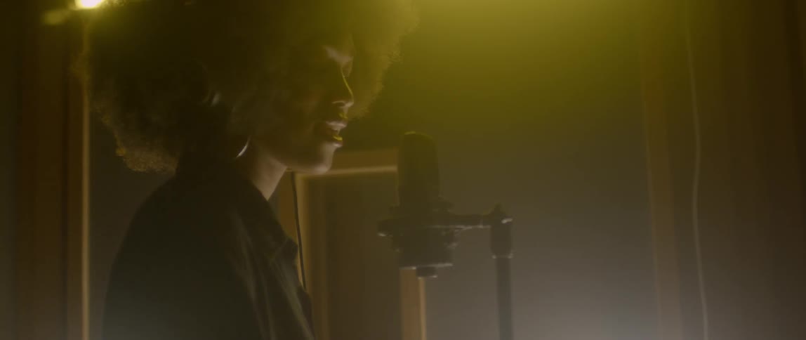 A woman sings into a microphone