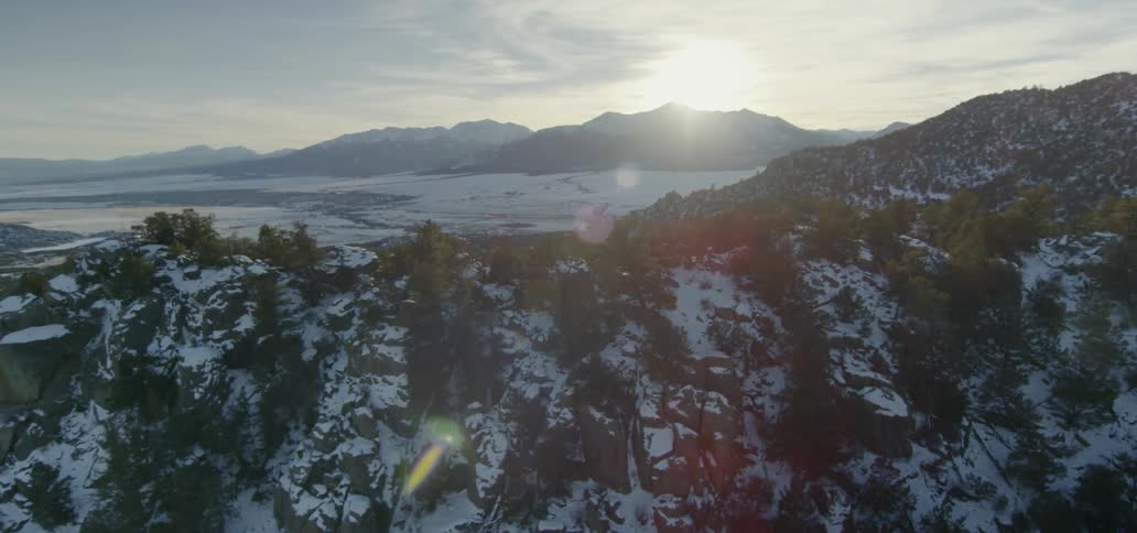 The sun rises over snowy mountains