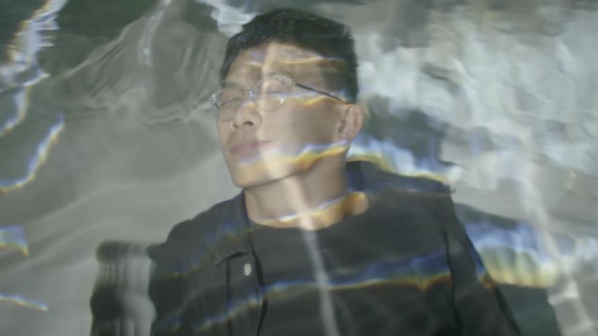 Water in a pool passes over a man