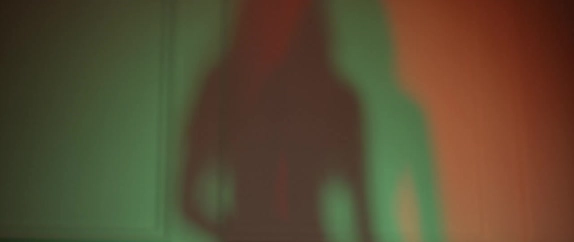 Green and red shadows of a dancing woman