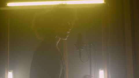 A woman records in a vocal studio