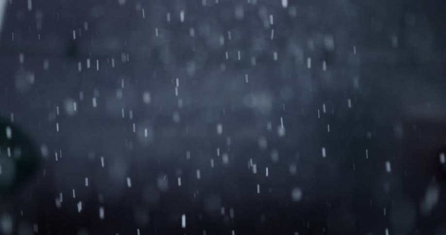 Snowflakes are falling outside at night