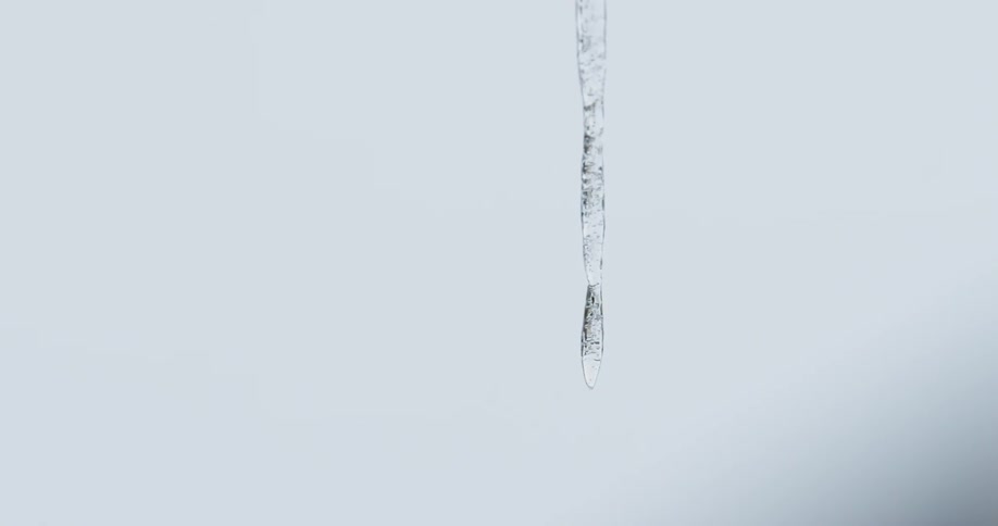The water slowly drips from the hanging ice