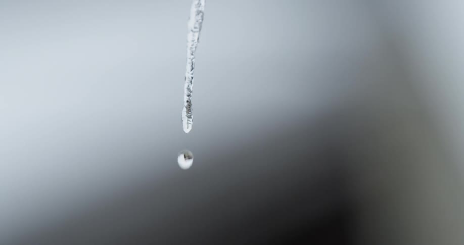 A drop of water falls from a small icicle