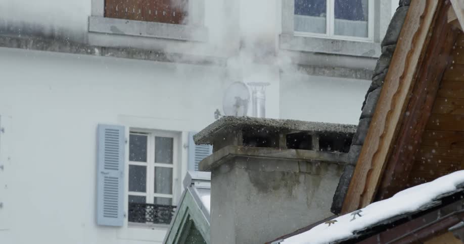 Steam rises from the chimney as it snows
