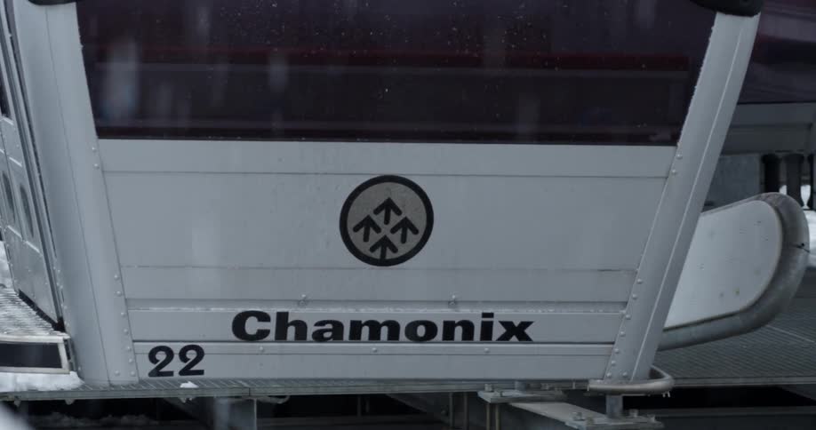The snow is falling as the gondola passes by
