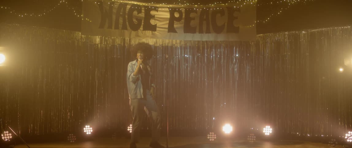 Woman sings and dances on stage by spotlights and tinsel