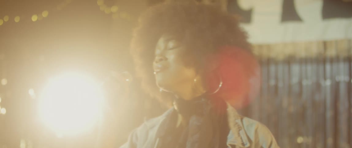 An african american woman is singing on a stage