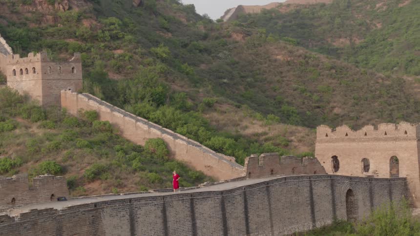 Woman walks on cement path leading away from a cement building