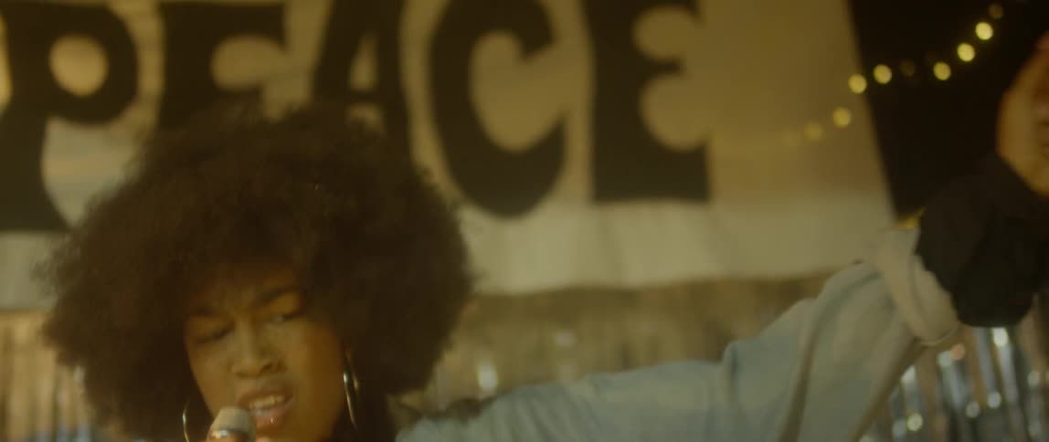 A woman dances and sings into a microphone