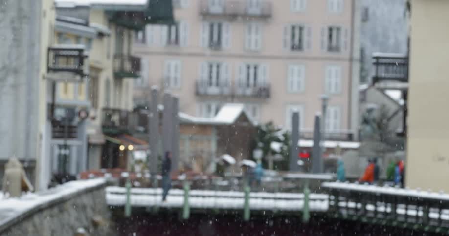 A person walks across a bridge on snowy day