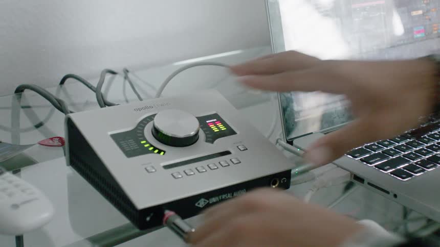 A person plugs a wire into the audio equipment