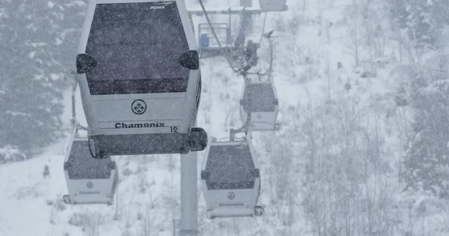 The ski lifts move as it snows heavily outside