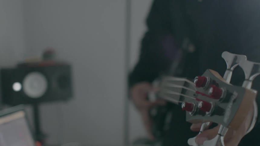 A guitarist tunes their bass guitar