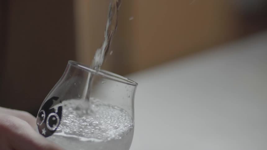 A person pours a can in a glass