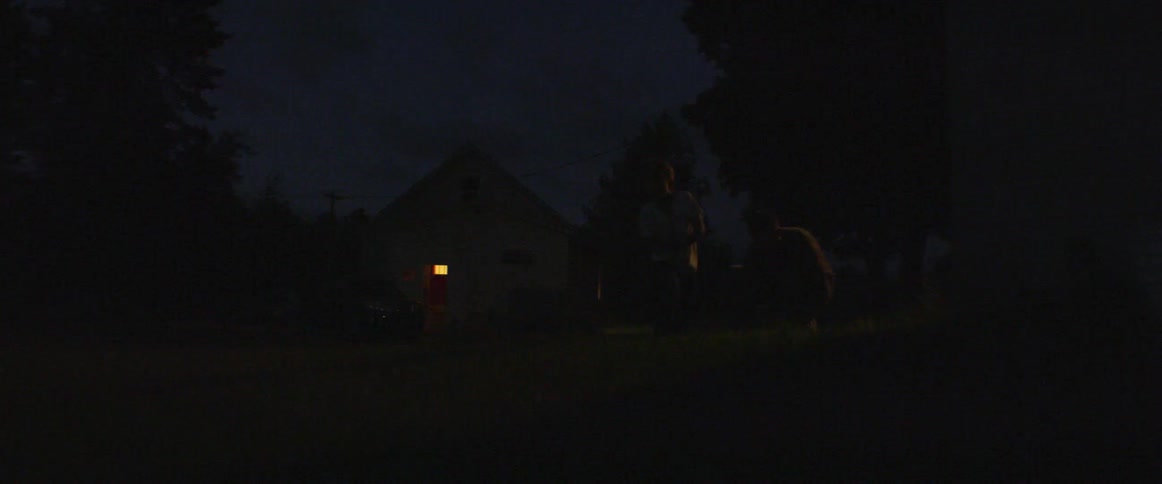 Two people are moving around on the dark field