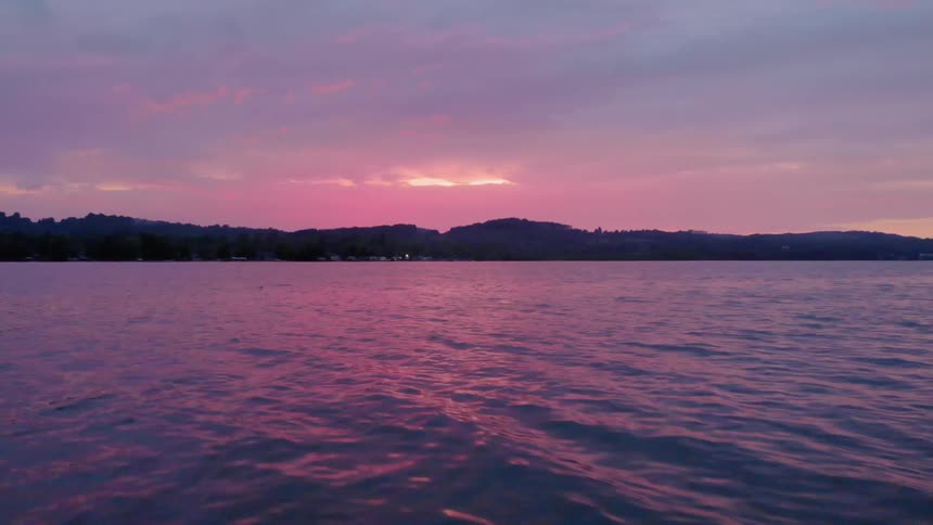The sun is setting over the lake creating a colorful sky