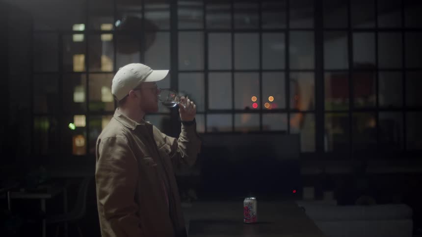 A man shakes his glass and drinks it all