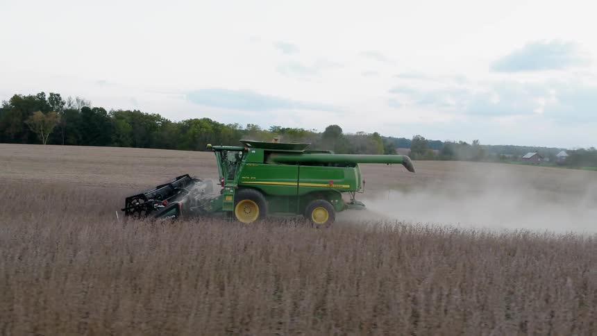 A combine is driven through a crop field