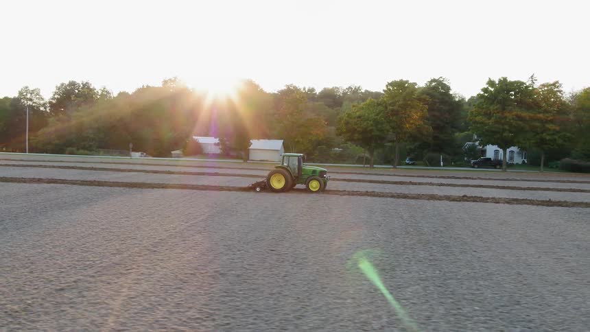 A tractor moves across the farm