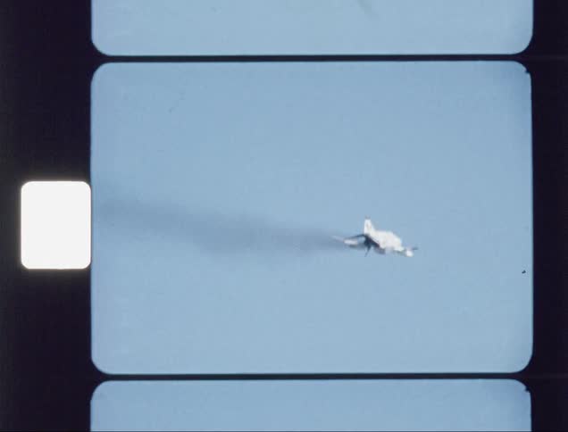 A smoking plane flies across the sky