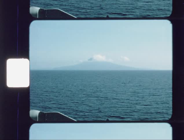 Clouds are hovering over an island mountain during the day