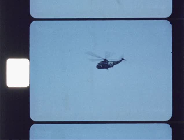Helicopters fly over the ocean