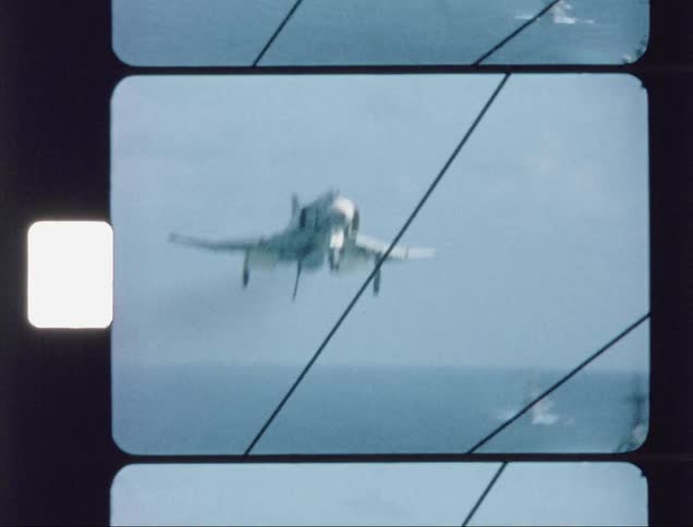 Military jet lands on a ship in the ocean