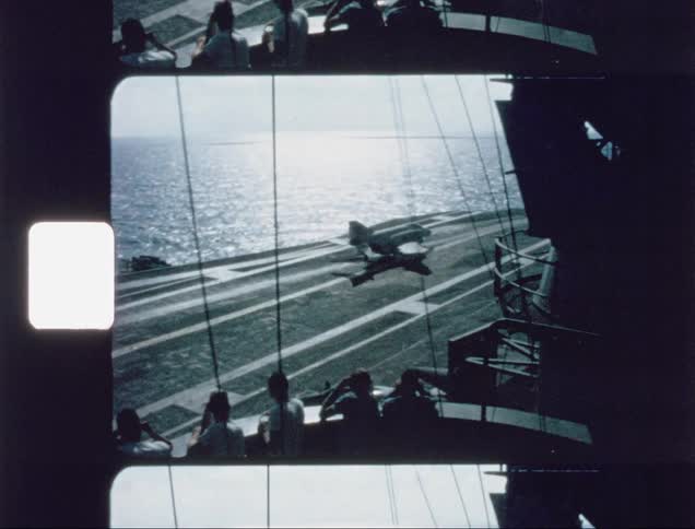 An airplane lands on an aircraft carrier