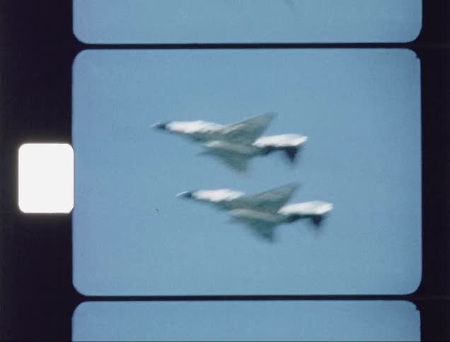 Two jets fly high in the blue sky