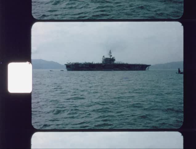 Aircraft carrier ship floats in the water ahead