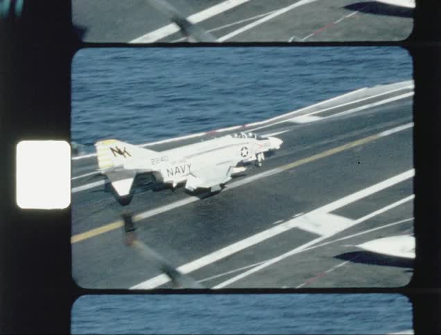A jet lands on an aircraft carrier at sea