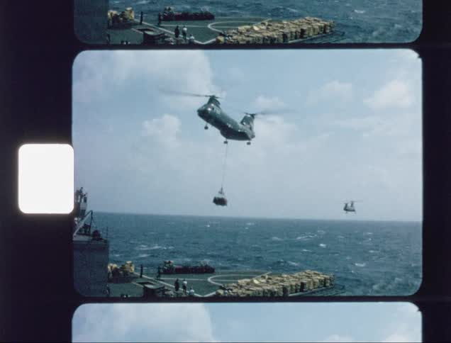 The large chopper lifts up some cargo from a ship