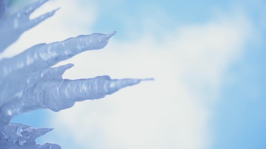 Icicles hang under a blue sky