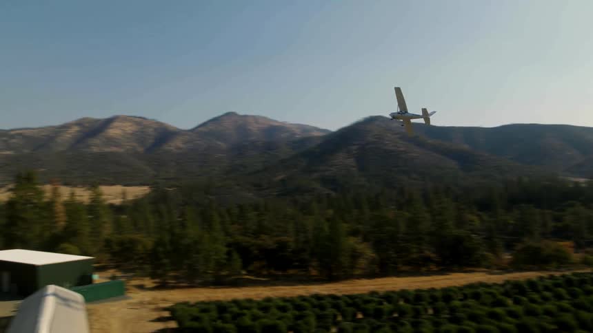 A plane flies over a farm