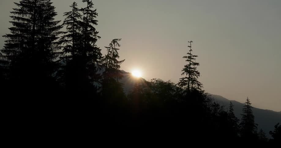 The shines over the crest of a mountain