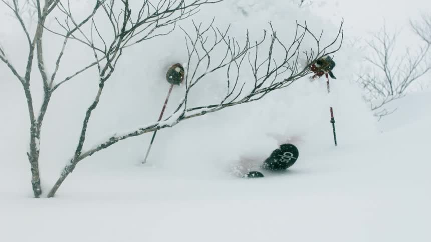 A skier is turning through deep snow in a storm